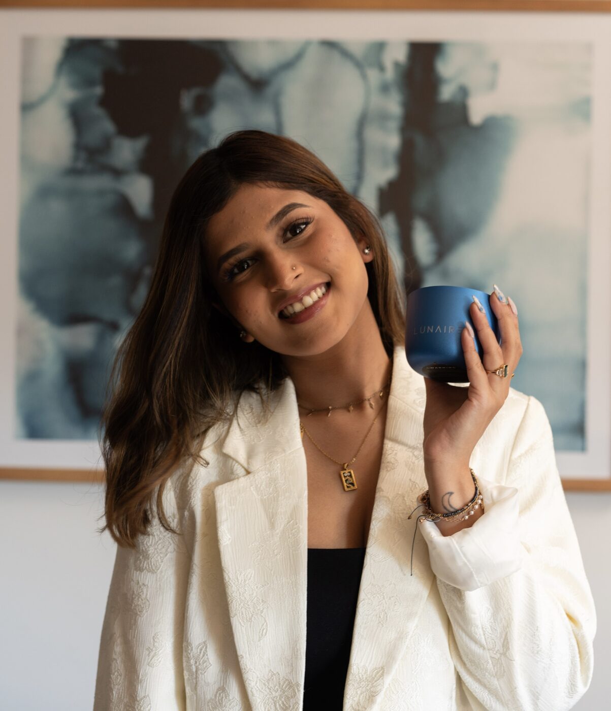 Krish Waje holding a Lunaire candle, the brand she founded